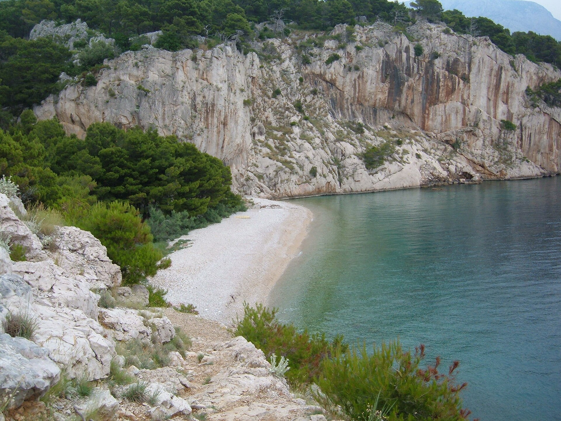 Kiezelstrand Nugal bij Makarska met helder water en rotswanden